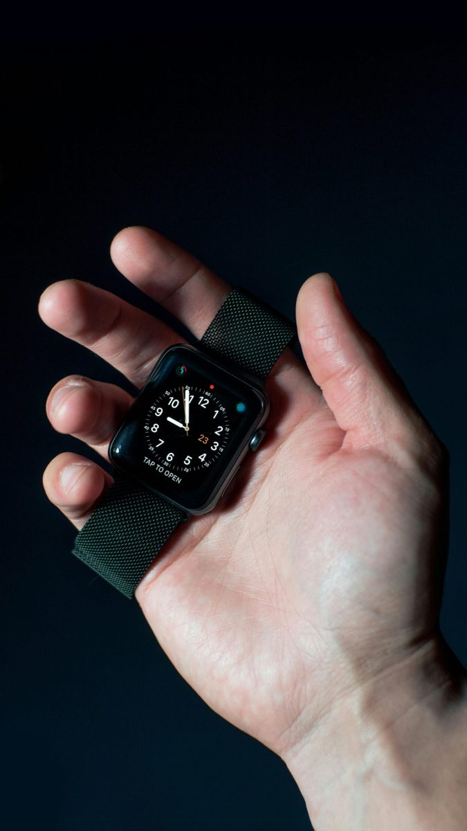 Close-up of a man wearing a white t-shirt and smartwatch in a casual setting.